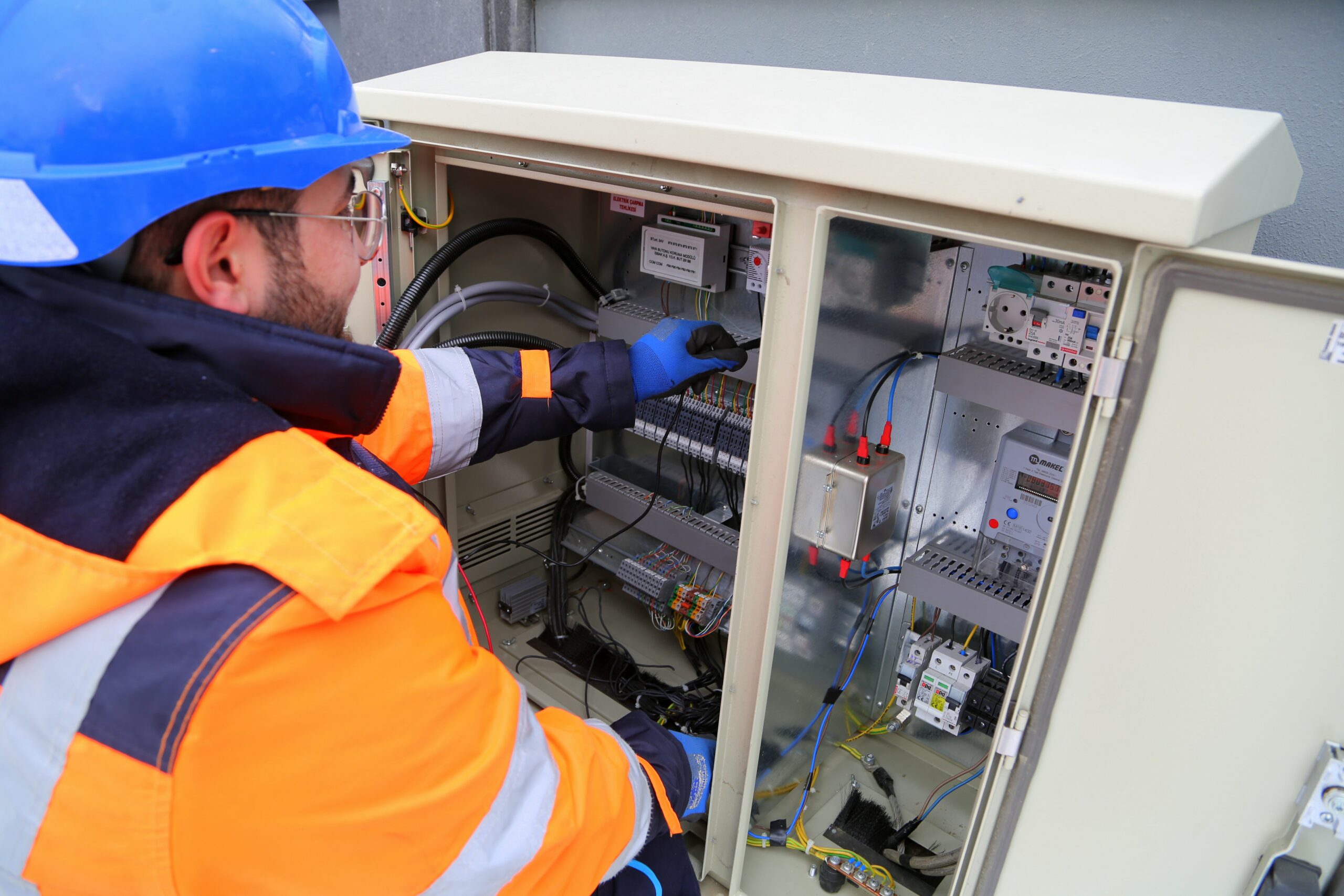 Electricien en maintenance devant un panneau électrique